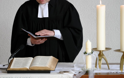 Un pasteur en robe lors d’une célébration. / ©iStock / Freder 